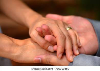 Both Hands Hands Of A Female And Male Married Couple Are Holding Onto One Another 