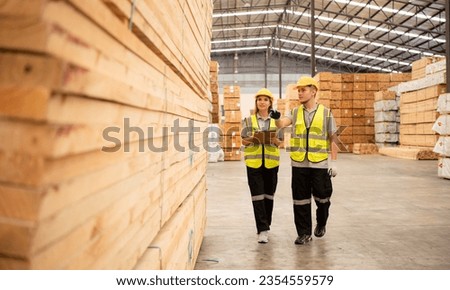 Both of workers work in a woodworking factory, Checking inventory the wood in the wooden warehouse
