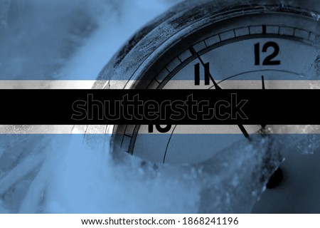 Botswana, Batswana flag with clock close to midnight in the background. Happy New Year concept