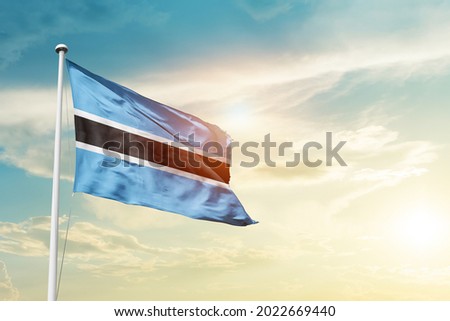 Botswana national flag waving in beautiful clouds.