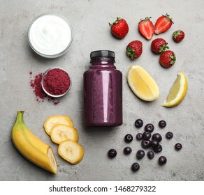 Bottle Of Acai Drink And Ingredients On Grey Background, Flat Lay