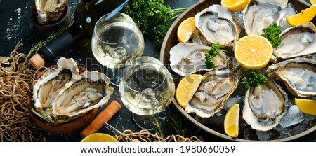 Bottle of aged wine and fresh oysters on a dark kitchen table. Seafood. Top view. Flat lay.