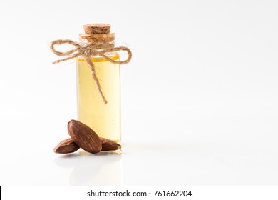 Bottle of almond oil and almonds isolated on white background