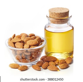 Bottle of almond oil and bowl of almonds isolated on white background