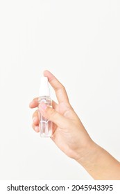 Bottle with antibacterial antiseptic spray in hand isolated on white background. A preventive hygiene measure against coronavirus ( Sars-CoV-2, Covid-19) infection. - Shutterstock ID 2045943395