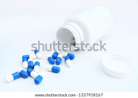 Bottle of blue and white pills isolated on white. Medicine. Medication