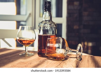 bottle of brandy and two glasses of alcohol in a bar