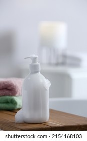 Bottle Of Bubble Bath With Foam And Towels On Tub In Bathroom