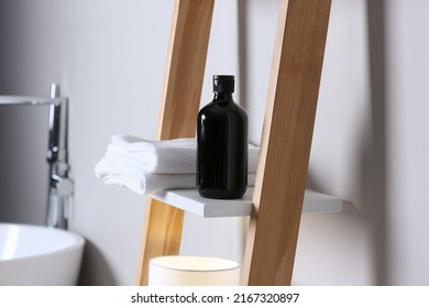 Bottle Of Bubble Bath And Towels On Shelf In Bathroom