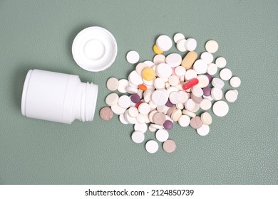 Bottle and a bunch of expired pills green background