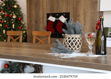 Bottle of champagne, glasses and Christmas decor on wooden table in kitchen, closeup - Powered by Shutterstock