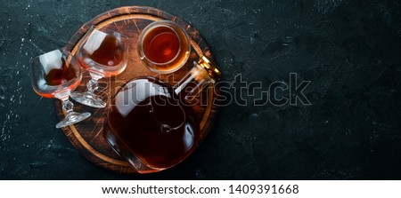 A bottle of cognac and glasses on a black background. Brandy. Top view. Free space for your text.