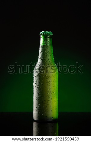 Bottle of cold beer  on dark green background. Vertical format.