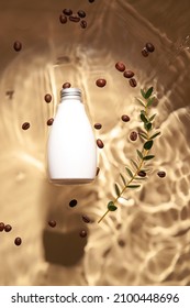 Bottle Of Cosmetic Product, Coffee Beans And Plant Branch In Water On Color Background