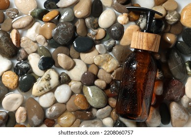 Bottle Of Cosmetic Product On Wet Stones, Top View. Space For Text