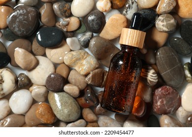 Bottle Of Cosmetic Product On Wet Stones, Top View. Space For Text