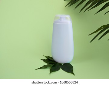 Bottle Of Cosmetics For Skin Care, Shampoo, Cream, Natural Cosmetics With Tea Tree Leaves, Tropical Leaves On A Blue Background.