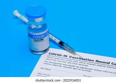Bottle of covid-19 vaccine, dose record card, and medical syringe prepared at clinic for doctor to inject volunteer to activate immune people to prevent pathogen outbreak