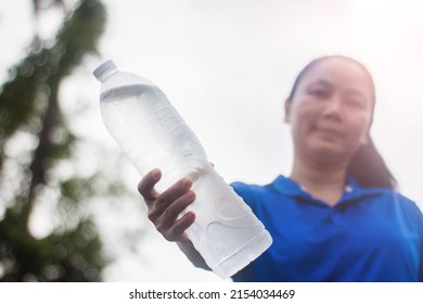 Bottle Of Drinking Water On Hand Of Middle Aged Asian Woman After Running To The Park In City 