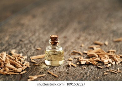 A bottle of essential oil with cedar wood chips, with copy space
