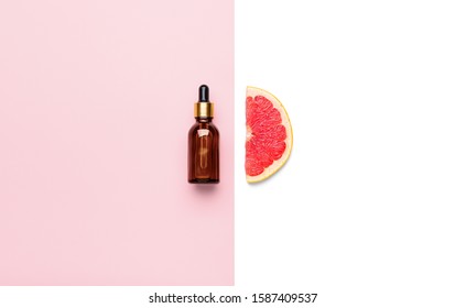 Bottle Of Essential Oil And Grapefruit Slice On Color Background