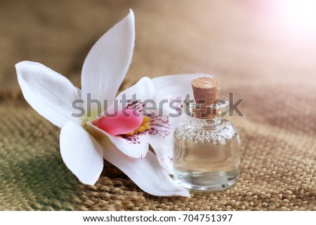 bottle of essential oil and orchid flowers