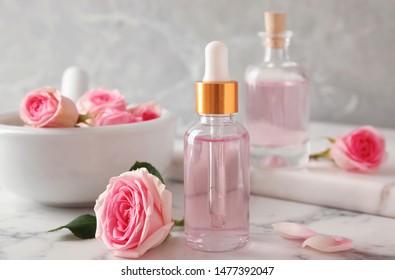 Flasche ätherischen Öls und Rose auf Marmortisch