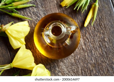 A Bottle Of Evening Primrose Oil With Blooming Oenothera Biennis Plant, Top View