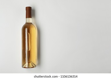 Bottle of expensive white wine on light background, top view