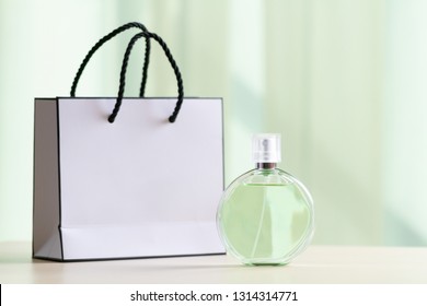 Bottle Of Famous Favorite Women Perfume And A Gift Paper Bag On Table At Home 