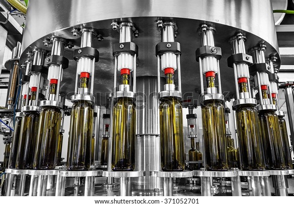 bottle filling,wine bottles filled with wine\
by an industrial machine in a wine\
factory