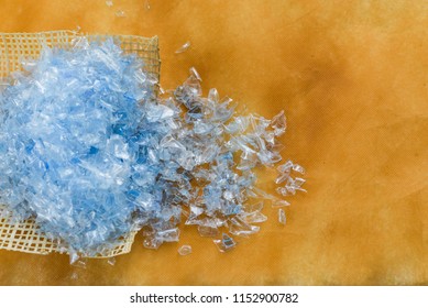 Bottle Flake,PET Bottle Flake,Plastic Bottle Crushed,Small Pieces Of Cut Blue Plastic Bottles On Yellow Background