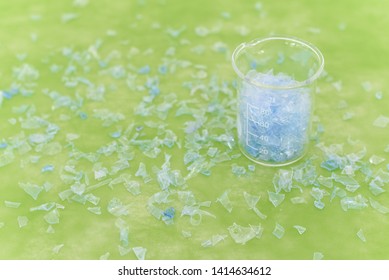 Bottle Flake,PET Bottle Flake,Plastic Bottle Crushed,Small Pieces Of Cut Blue Plastic Bottles In Beaker Glass.Chemical Concept