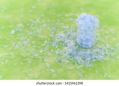 Bottle Flake,PET Bottle Flake,Plastic Bottle Crushed,Small Pieces Of Cut Blue Plastic Bottles In Beaker Glass.Chemical Concept