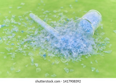 Bottle Flake,PET Bottle Flake,Plastic Bottle Crushed,Small Pieces Of Cut Blue Plastic Bottles In Beaker Glass.Chemical Concept