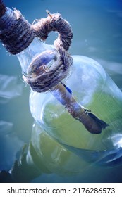 Bottle Floating On Water With A Rolled Letter Inside.Message Call For Help