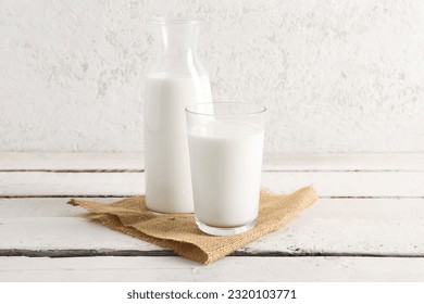 Bottle and glass with fresh milk on light wooden table - Powered by Shutterstock