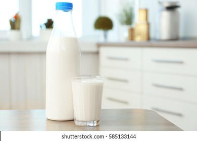Bottle and glass of milk on table in kitchen