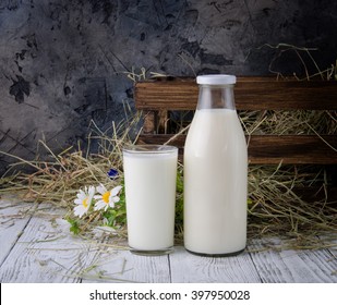 A bottle and glass of milk on a wooden table