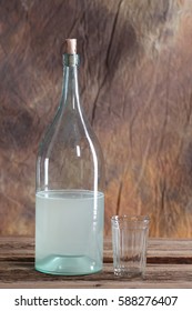 The Bottle And Glass Of Moonshine On The Old Wooden Table 