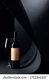 Bottle And Glass Of Red Wine On A Black Background. Bottle With Empty Old Paper Label. Copy Space.