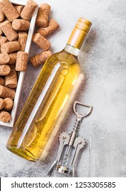 Bottle And Glasses Of White Wine With Box Of Corks And Crkscrew Opener On Stone Kitchen Table Background. Top View. 