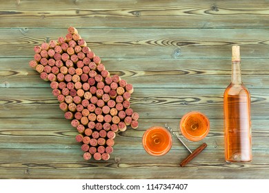 Bottle And Glasses Of Wine And Corkscrew With Napa Valley Map Formed Of Used Stained Red Wine Corks On Rustic Wood With Copy Space In A Viticulture Concept