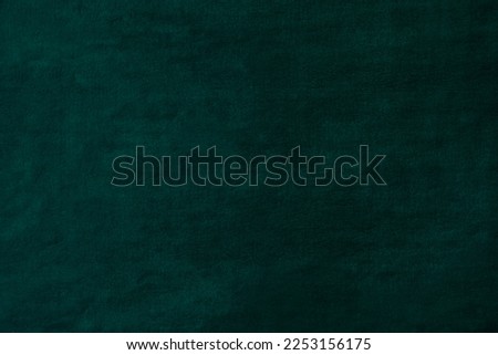 Bottle green velvet uneven background for design or photography backdrop. Malachite green uneven texture can be used as canvas or banner with space for logo or design.
