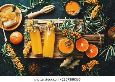 A bottle of homemade drink with honey, sea buckthorn and vitamin C. Autumn drinks. On a dark background. Top view.