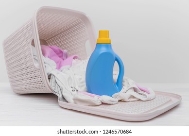 Bottle Of Laundry Detergent In A Basket Of Dirty Baby Clothes. Close-up.