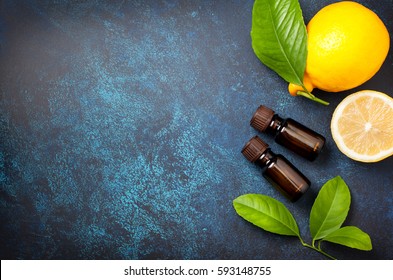 Bottle With Lemon Essential Oil, Fresh Lemon On A Blue Background