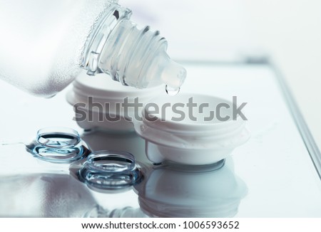 Bottle with lens solution and case on table