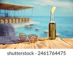 Bottle of light beer with slice of lemon standing on wooden table on beach bar with sea background. Concept of summer, vacation, relaxation, travelling, leisure time