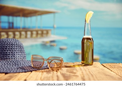 Bottle of light beer with slice of lemon standing on wooden table on beach bar with sea background. Concept of summer, vacation, relaxation, travelling, leisure time - Powered by Shutterstock